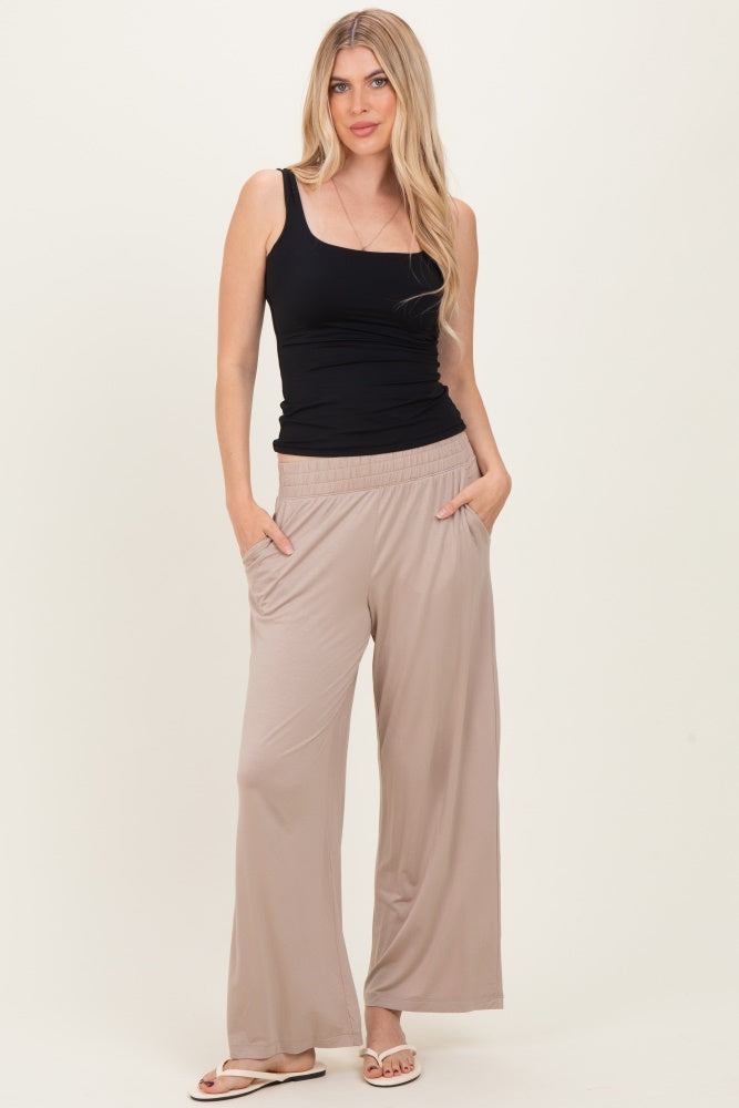 woman wearing a black sleeveless top and beige wide-legged pants with pockets