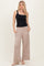 woman wearing a black sleeveless top and beige wide-legged pants with pockets