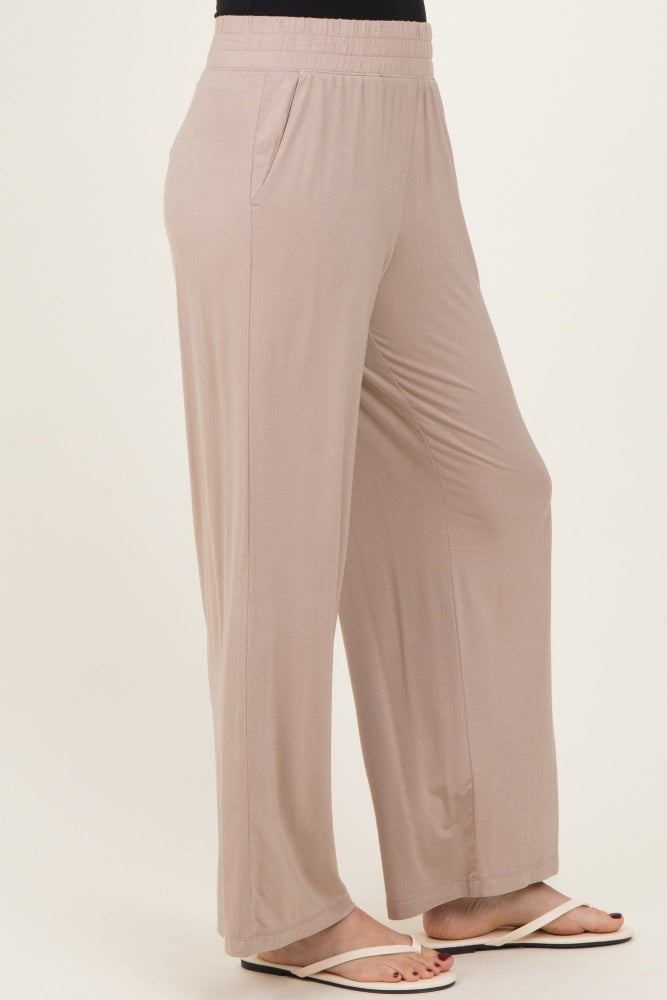 woman wearing light beige wide leg pants with an elastic waistband and side pockets