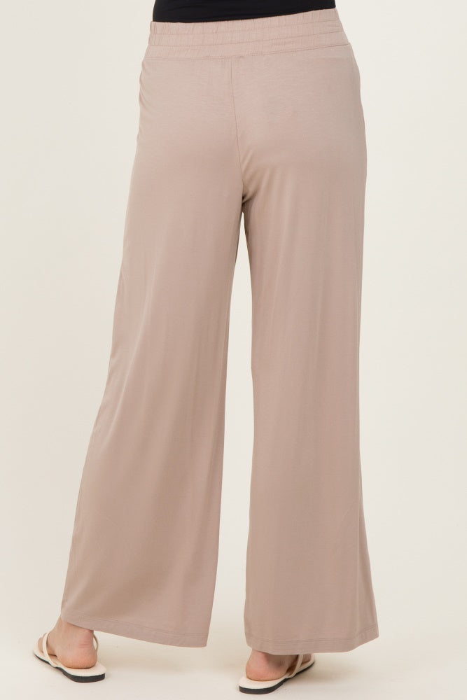woman wearing beige wide-leg trousers with an elastic waistband, viewed from the back