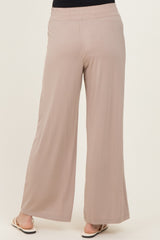 woman wearing beige wide-leg trousers with an elastic waistband, viewed from the back