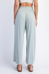 woman wearing light green wide-leg pants with an elastic waistband, viewed from the back