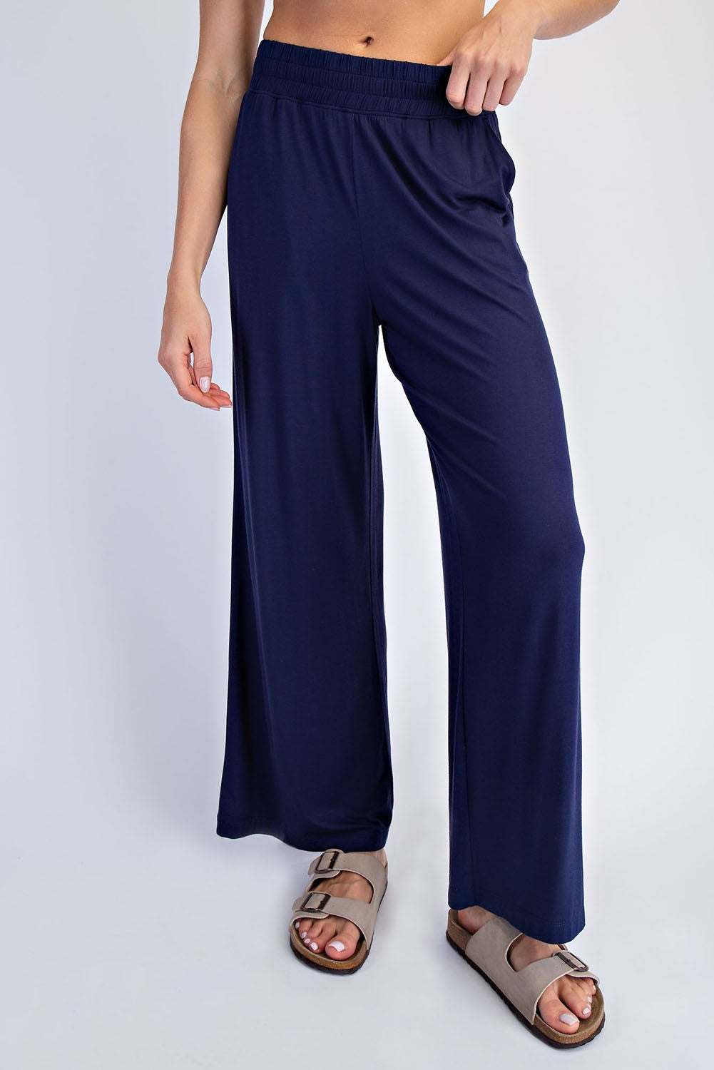 woman wearing navy blue wide-leg trousers with an elastic waistband and casual sandals