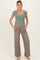 woman wearing a light green ribbed maternity top and taupe wide-leg maternity pants with pockets