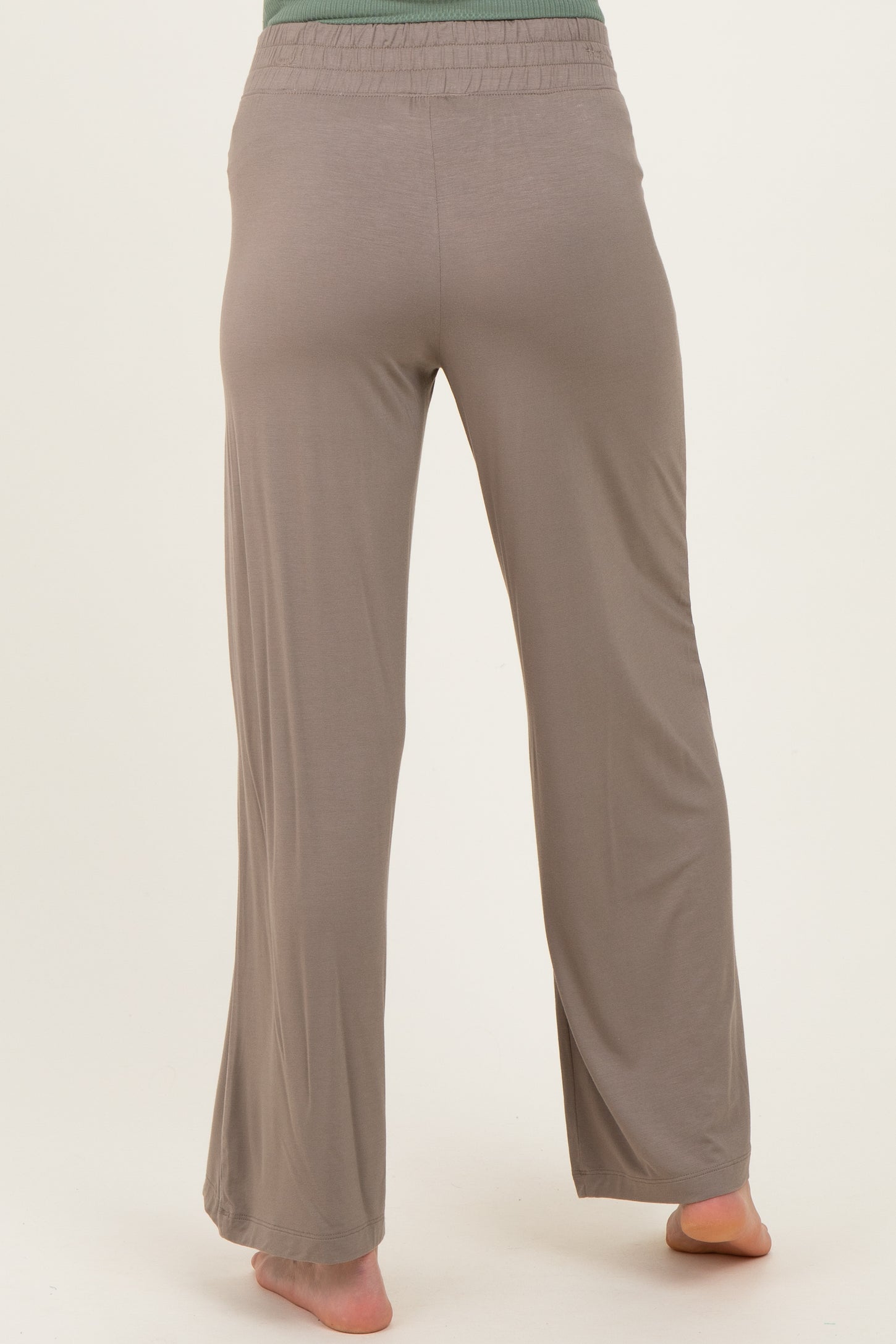 woman wearing light brown maternity lounge pants, seen from the back