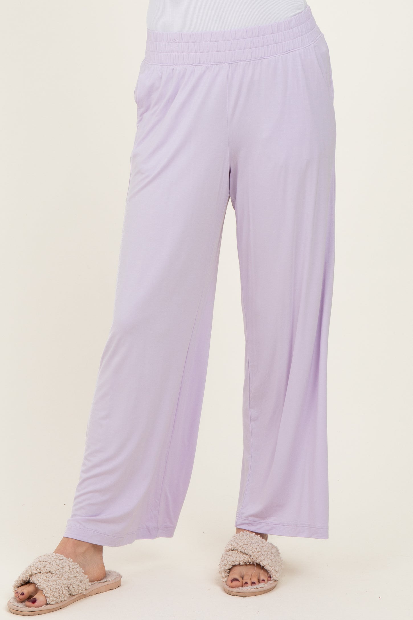woman wearing light purple wide-leg lounge pants and cozy slippers