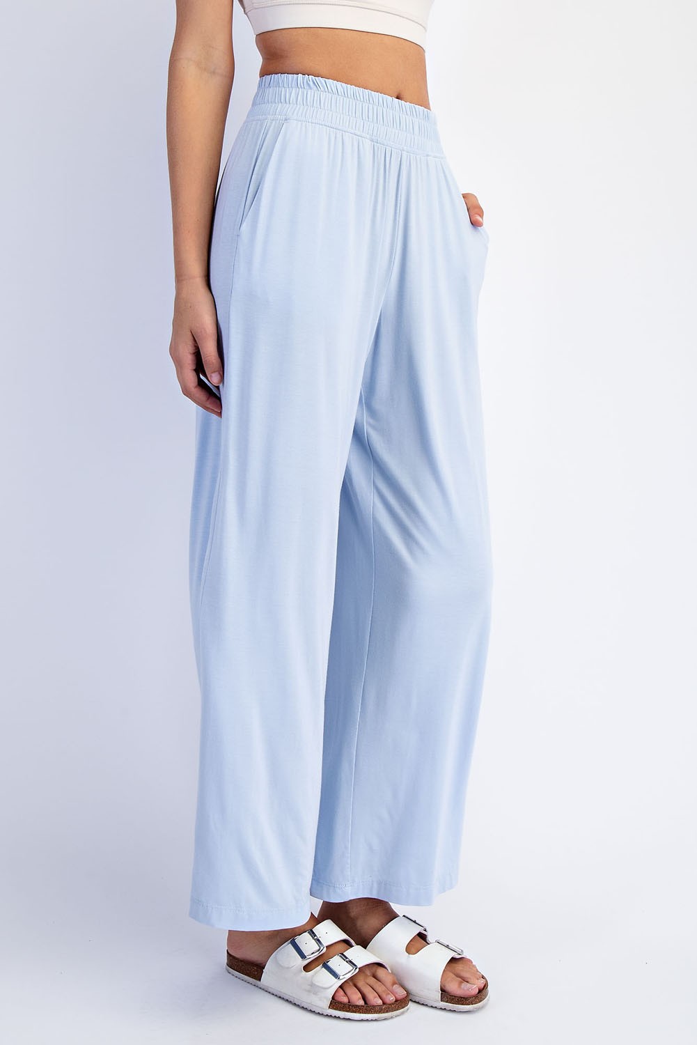 woman wearing light blue wide-leg flowy pants with an elastic waistband and side pockets