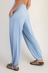 woman wearing light blue relaxed fit pants with side pockets and adjustable ties at the ankles