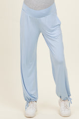 woman wearing light blue maternity lounge pants with a comfortable waistband and cinched ankles, styled with sneakers