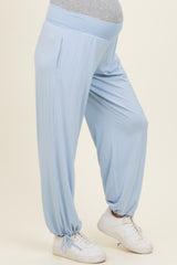 woman wearing light blue maternity pants with an elastic waistband and side pockets, paired with white sneakers