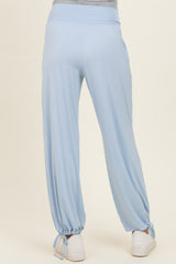 woman wearing light blue maternity pants with a relaxed fit and ties at the ankles, showing a baby bump