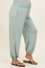 woman wearing light green maternity harem pants with adjustable drawstrings at the ankles