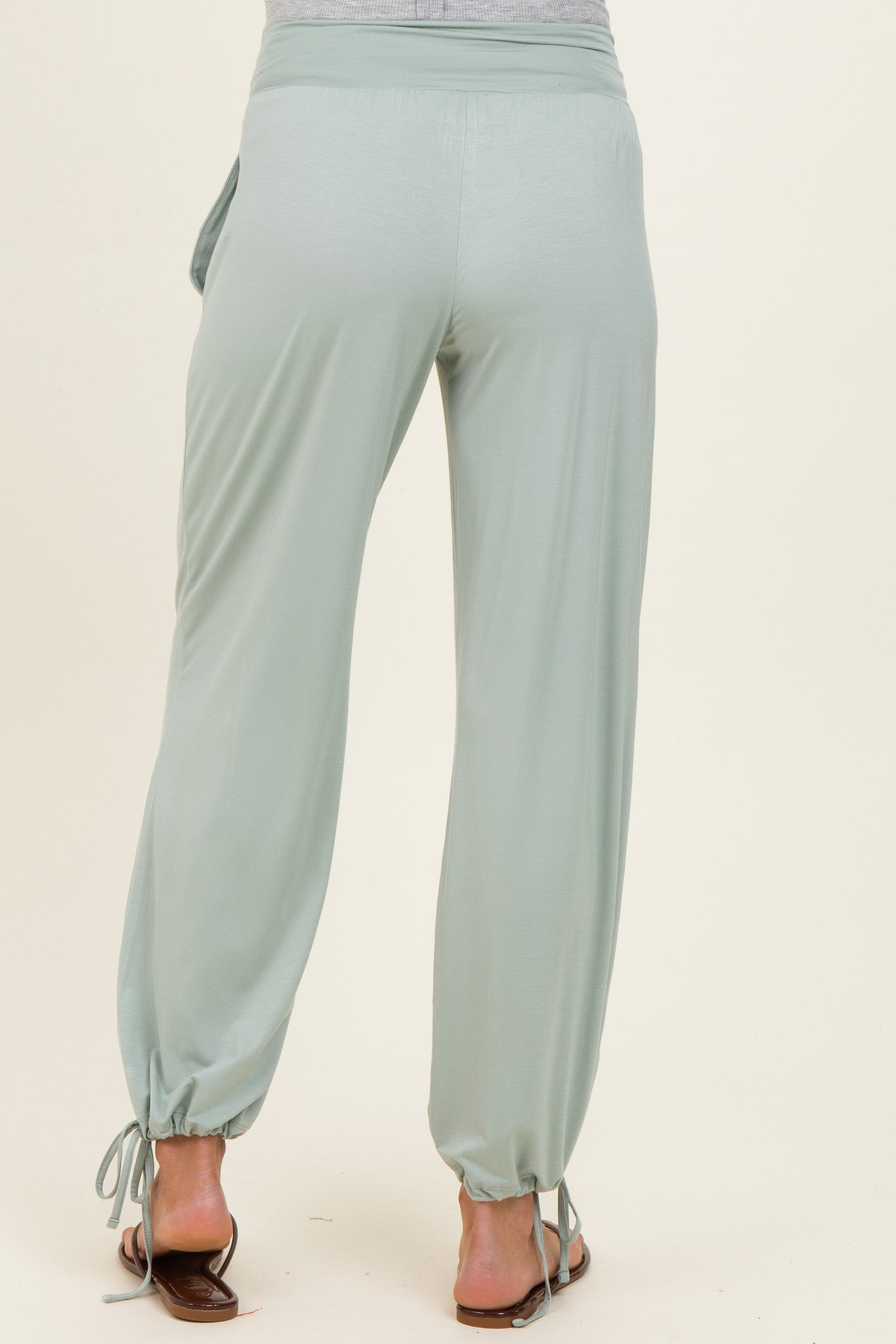 maternity wear in soft green fabric featuring drawstring cuffs and relaxed fit, model shown from the back