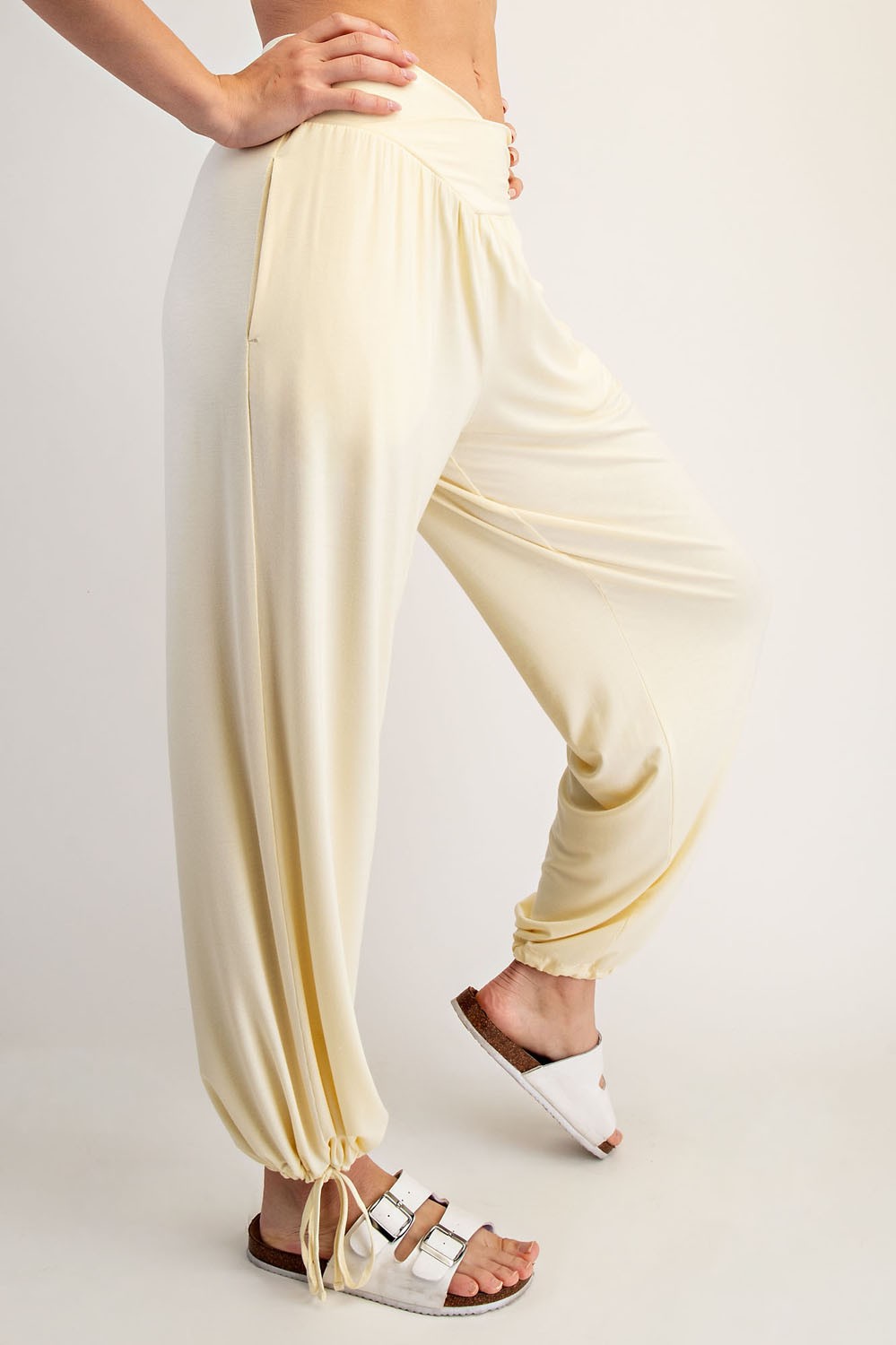 woman wearing light yellow harem pants with a relaxed fit and drawstring detail at the ankles