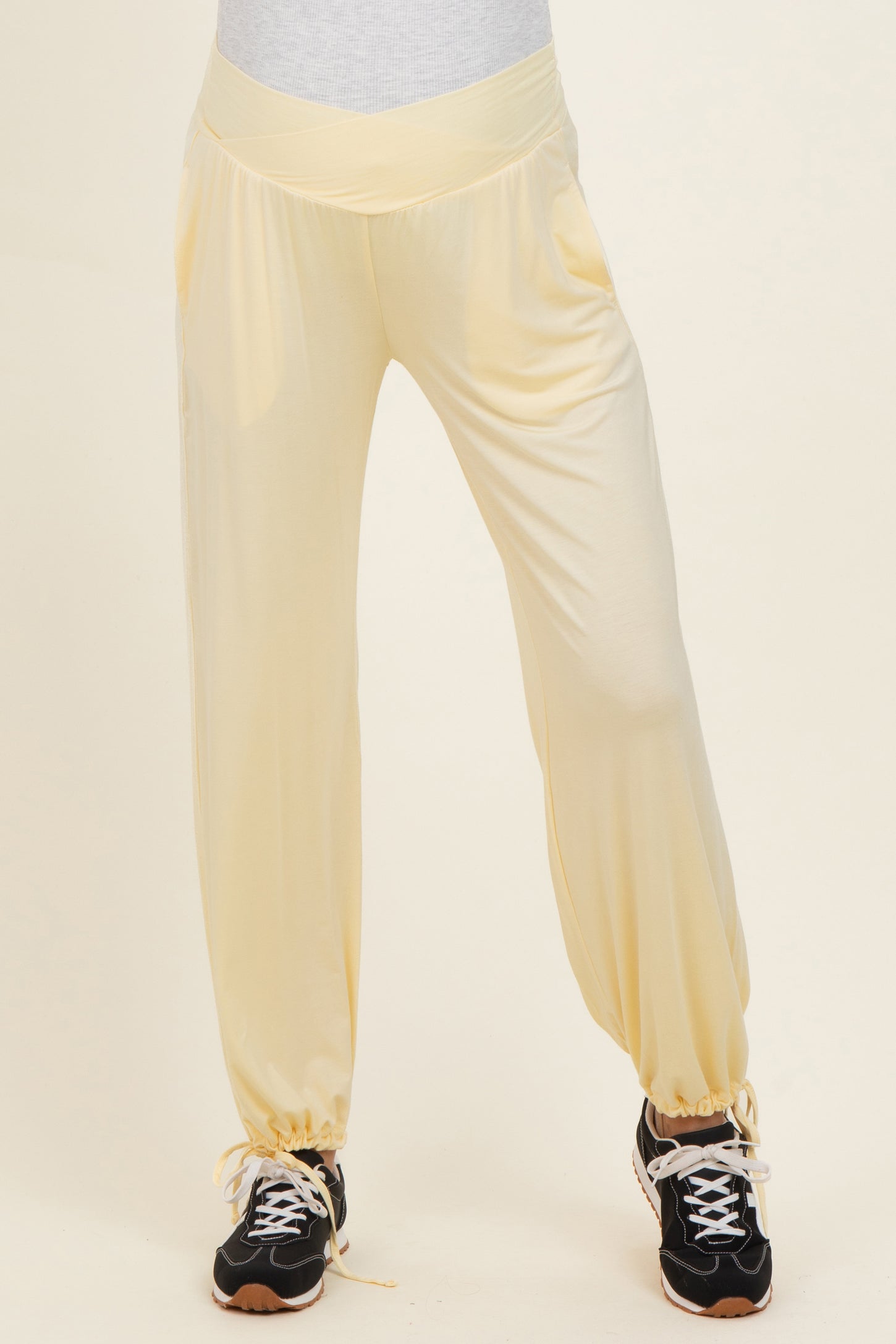 maternity wear in light yellow jogger pants with a comfortable elastic waistband and adjustable drawstring detail