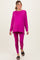 woman wearing a hot pink long sleeve maternity top and matching leggings, showing her baby bump