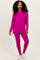 woman wearing a bright pink long sleeve top and matching leggings with white sneakers