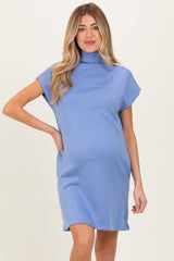 woman wearing a light blue short sleeve maternity dress with a mock neckline and visible baby bump