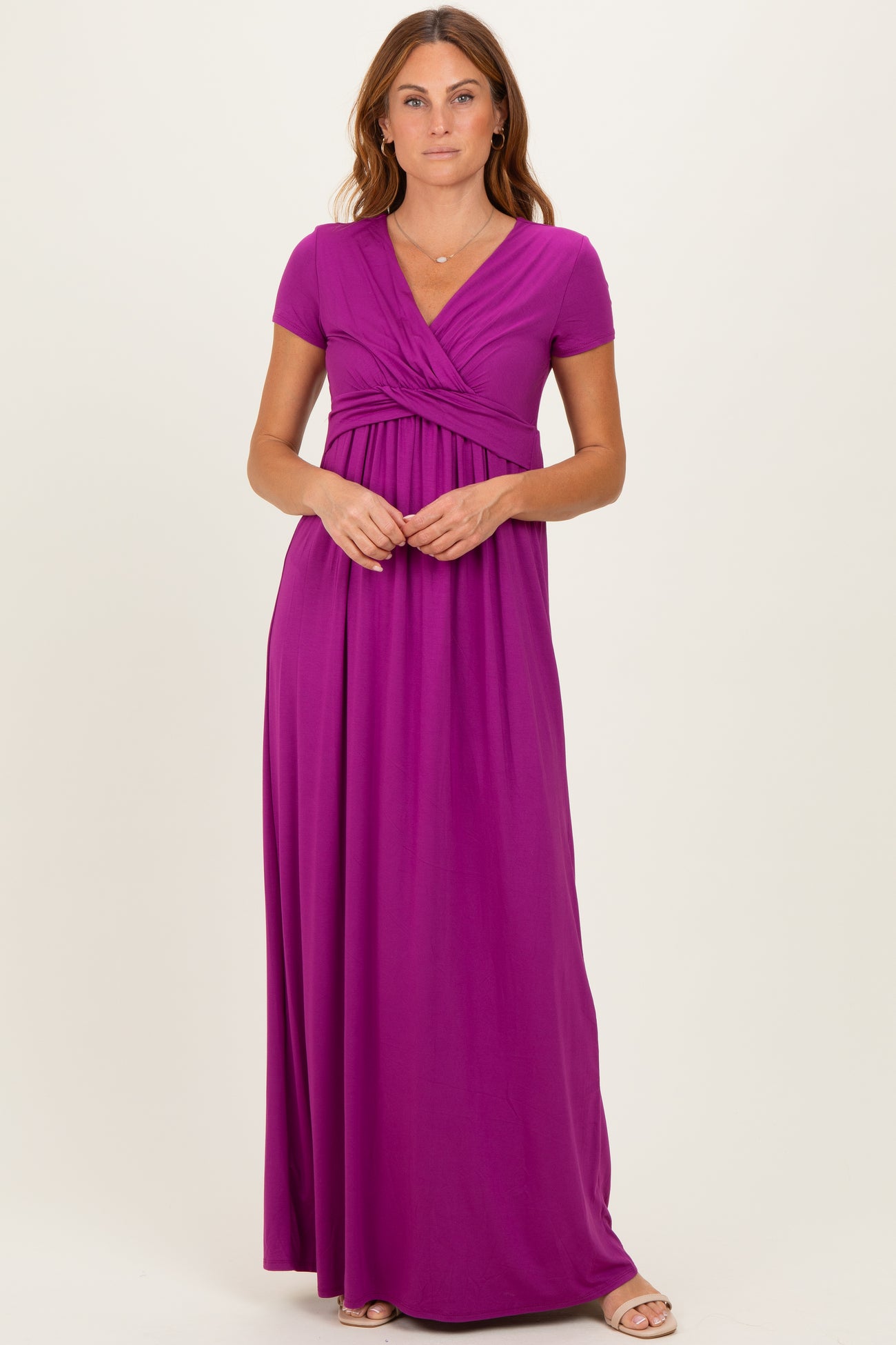 woman wearing a purple short sleeve maxi dress with a wrapped bodice and flowy skirt