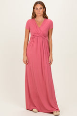 woman wearing a pink short sleeve maxi dress with a twisted front detail