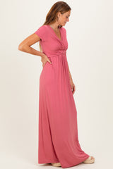 woman wearing a rose pink cap sleeve maxi dress with a twisted front detail and a relaxed fit