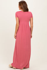 woman wearing a pink short sleeve maxi dress with a gathered waist and a flowy skirt, shown from the back