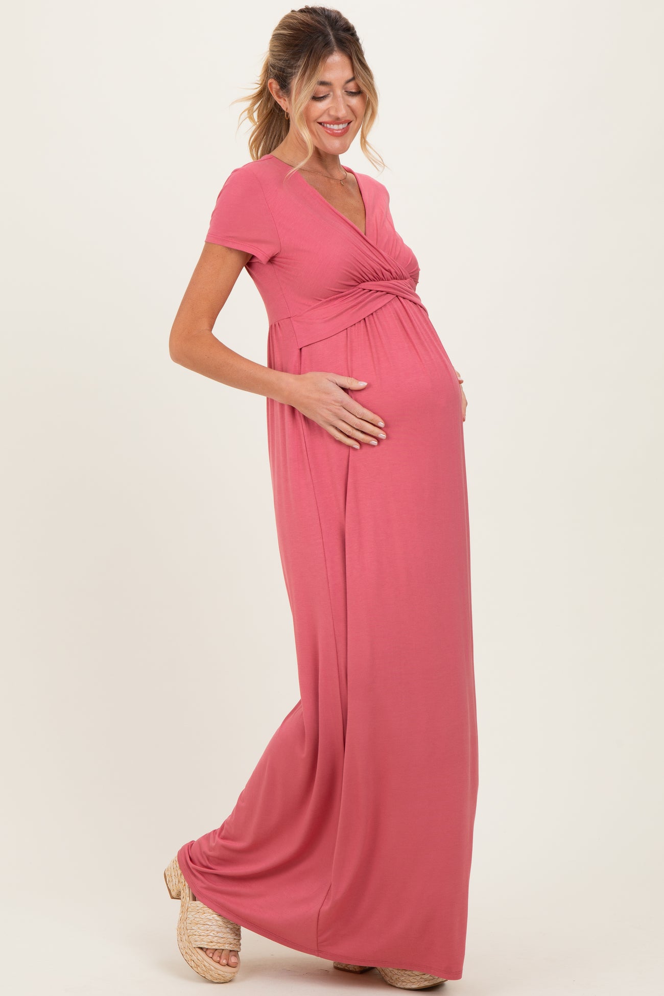 woman wearing a dusty rose maternity maxi dress with a wrap-style bodice and baby bump visible