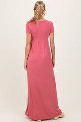 woman wearing a pink short sleeve maternity maxi dress, back view, showing a flowy silhouette and baby bump support