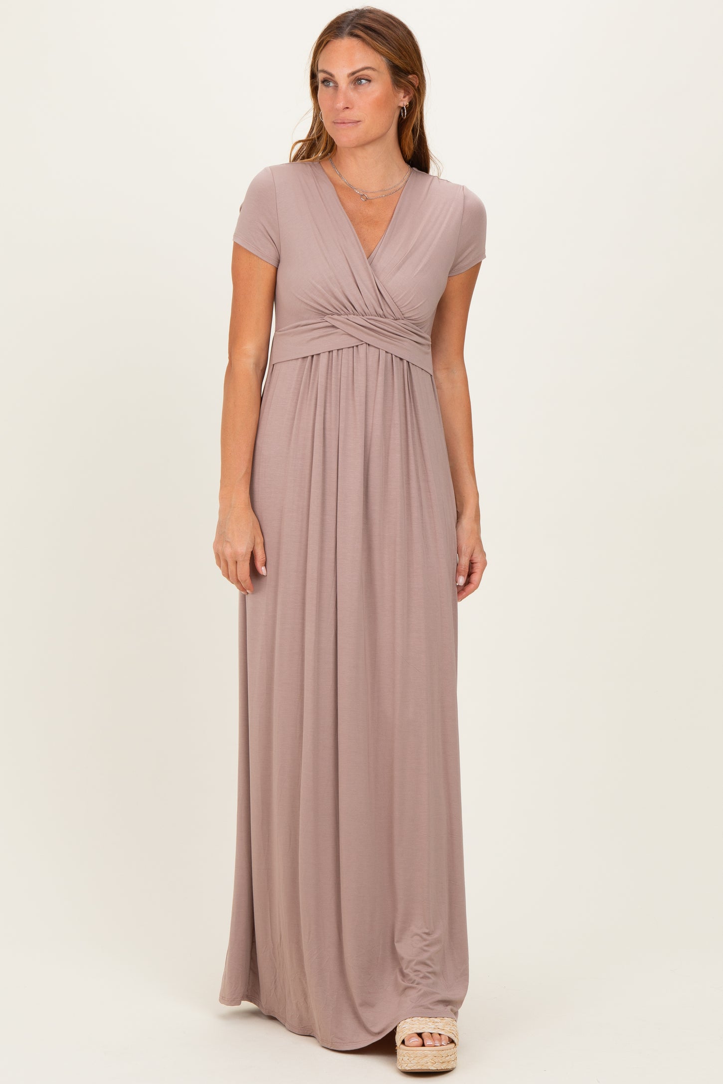 woman wearing a dusty rose short sleeve maxi dress with a wrap design and gathered waistline