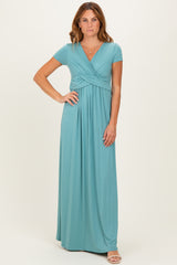 woman wearing a teal short sleeve maxi dress with a twist front detail and a flowing silhouette