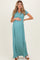 woman wearing a teal maternity maxi dress and holding her baby bump