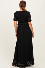 woman wearing a black lace maxi dress with short sleeves and a fitted waist, shown from the back