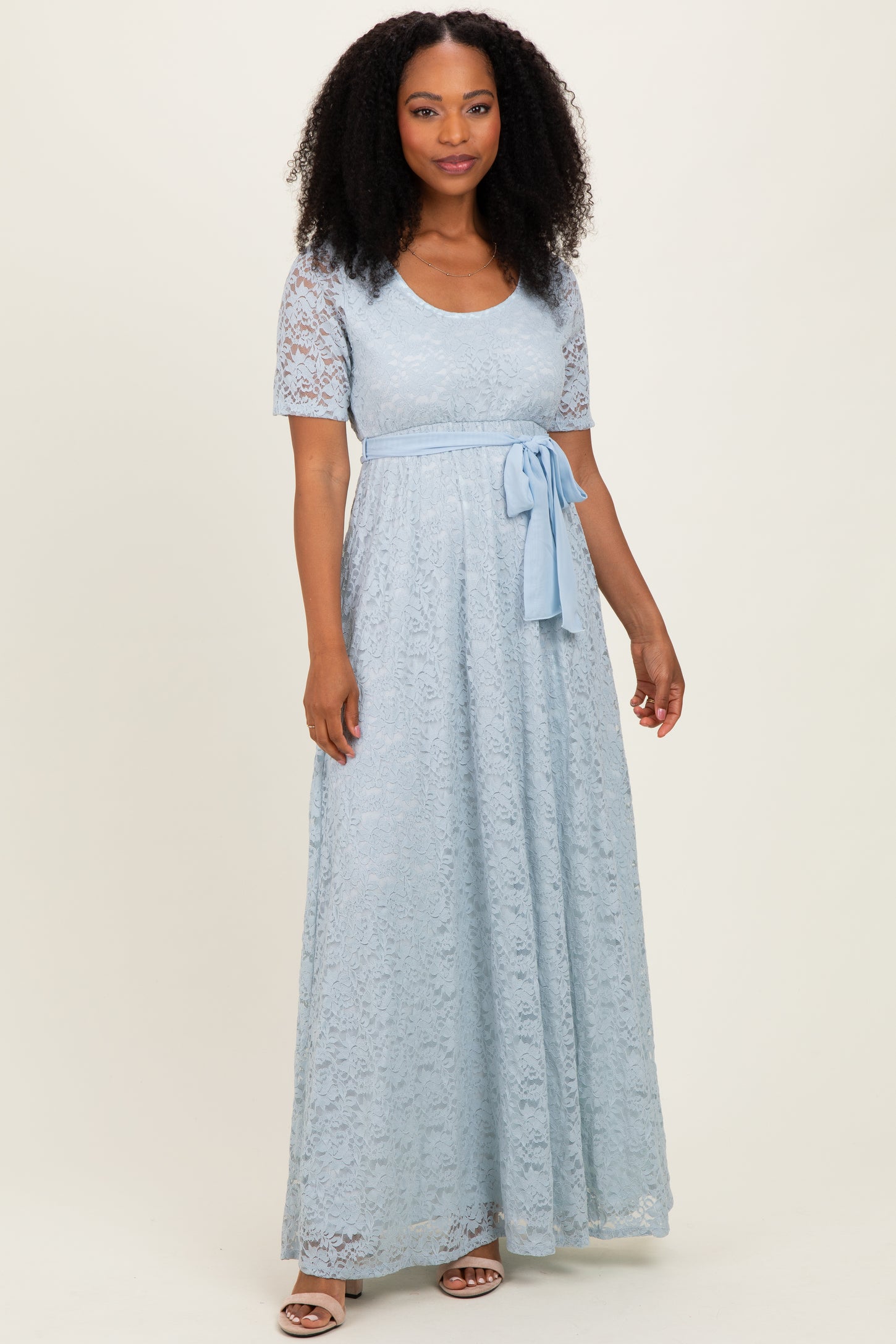 woman wearing a light blue lace maxi dress with short sleeves and a tied waist detail