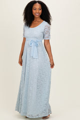 woman wearing a light blue lace maxi dress with short sleeves and a matching tie belt