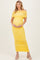 woman wearing a yellow off-the-shoulder maternity dress that hugs her baby bump with ruched detailing