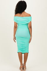 woman wearing a mint green off-shoulder bodycon dress with ruched detailing, shown from the back