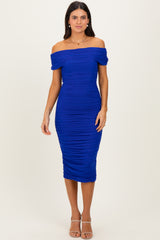 woman wearing a royal blue off-shoulder bodycon dress with ruched details and a midi length