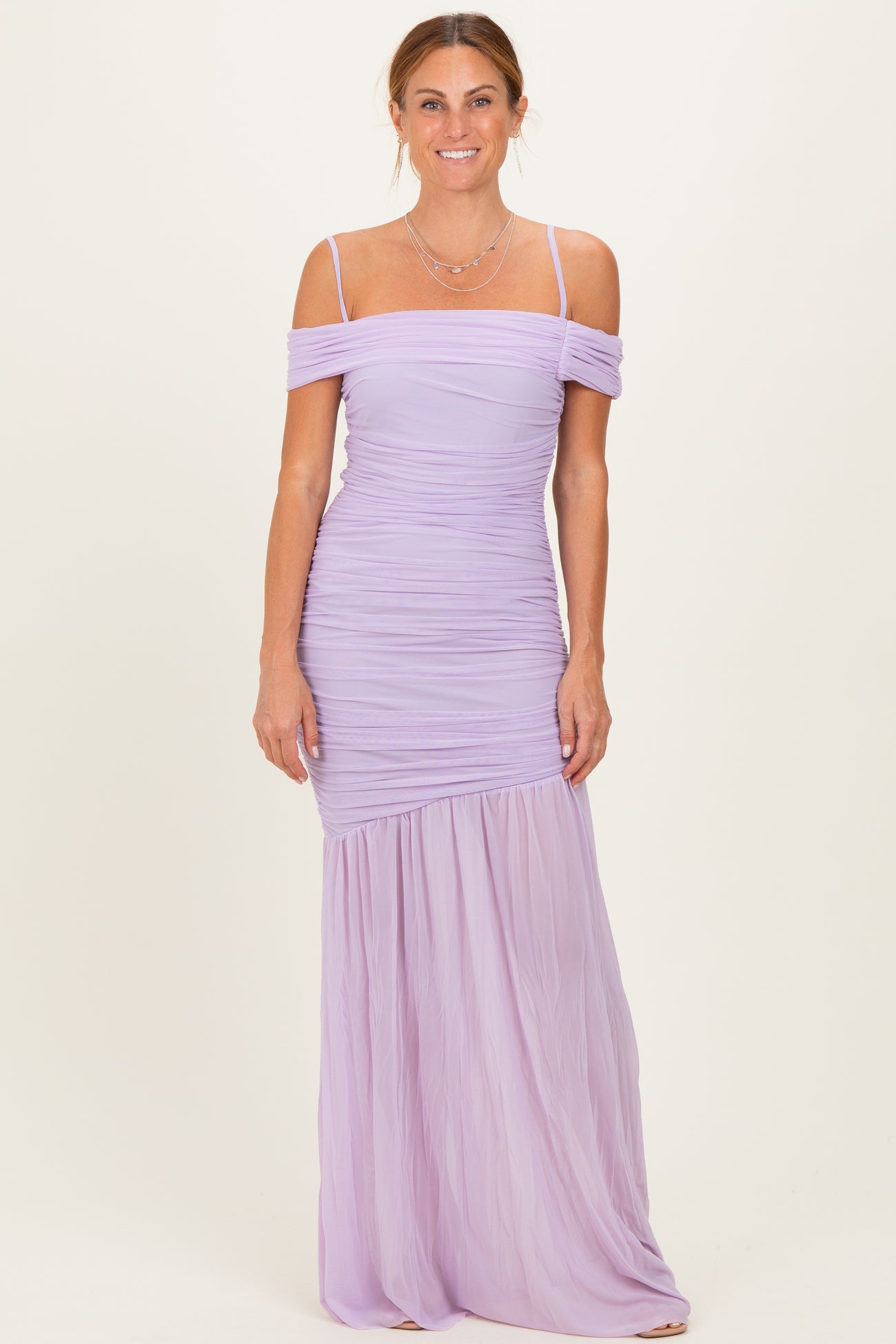woman wearing a lavender off-the-shoulder ruched maxi dress with a flowing lower skirt