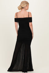 woman wearing a black off-the-shoulder fitted dress with ruching and a sheer maxi skirt