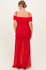 woman wearing a red off-shoulder maternity dress with ruching and a flowy skirt, showing a side view