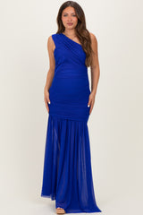 woman wearing a royal blue one-shoulder maternity gown with ruched detailing and a flowing skirt