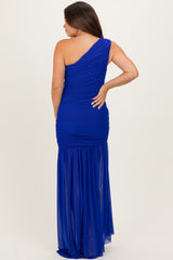 woman wearing a royal blue one-shoulder maternity dress with ruching and a flowing skirt