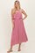 woman wearing a pink strapless maxi dress with a ruffled bodice and flowing skirt