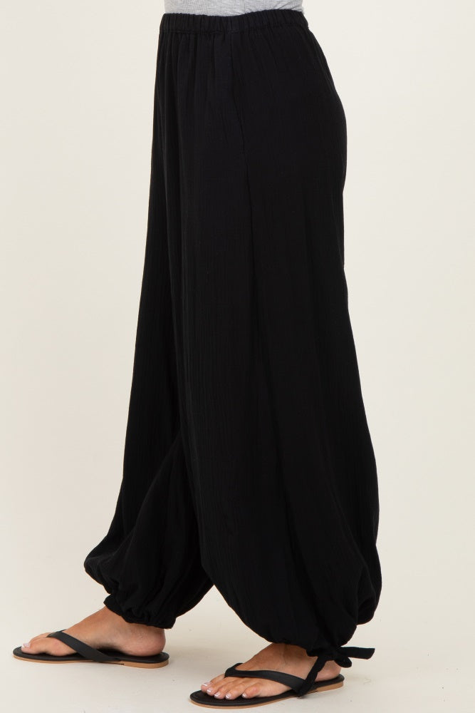 woman wearing black wide-leg harem pants with a relaxed fit and drawstring ankle detail