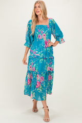 woman wearing a blue floral maxi dress with puff sleeves and tiered skirt