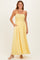 woman wearing a yellow maxi dress with smocked bodice and pockets, standing and smiling