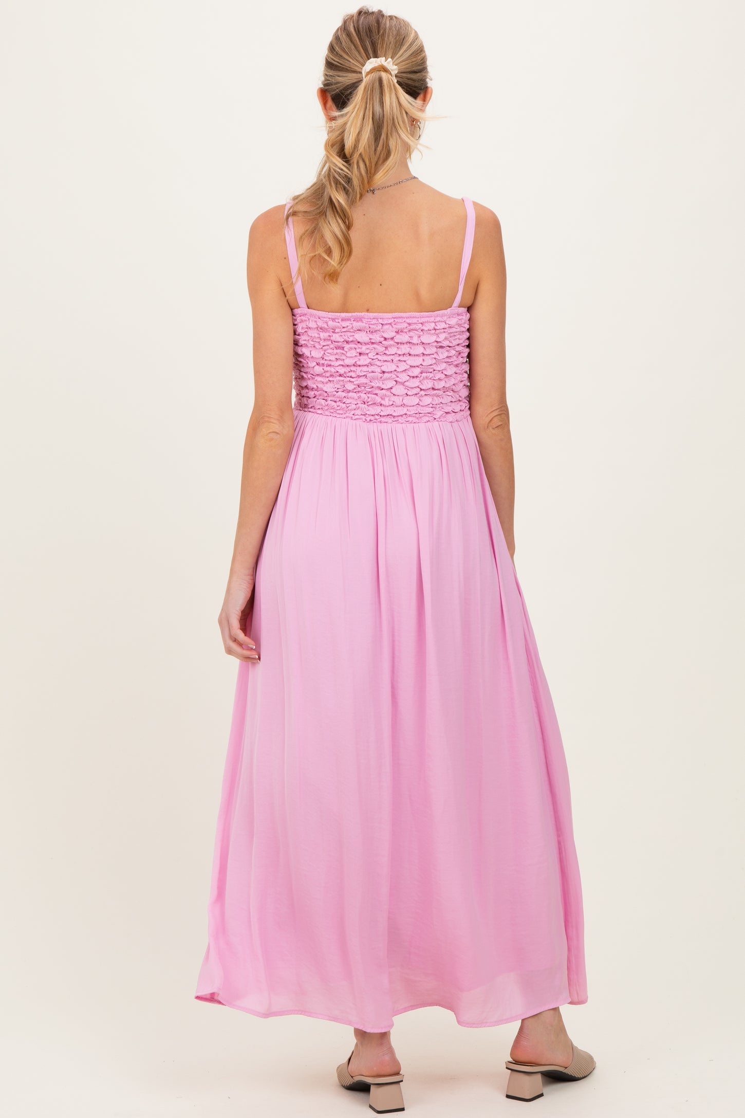 woman wearing a pink maternity maxi dress with smocked back and flowing skirt, showing a relaxed fit