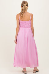 woman wearing a pink maternity maxi dress with smocked back and flowing skirt, showing a relaxed fit