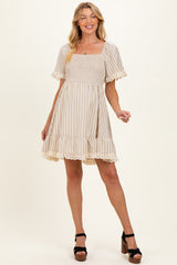 woman wearing a beige striped maternity dress with short sleeves and lace trim, smiling and posing