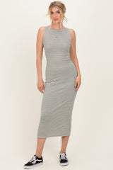 woman wearing a gray and white striped sleeveless midi dress with a fitted silhouette and black sneakers